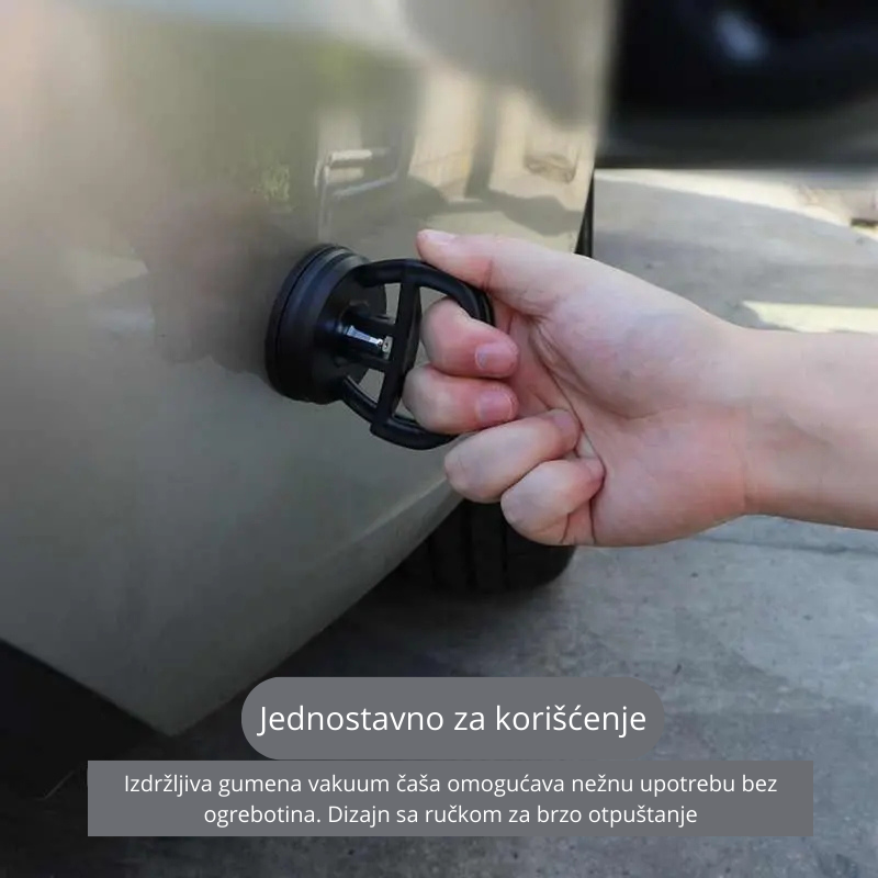 Osoba koristi gumenu vakuum čašu za izvlačenje udubljenja na automobilu